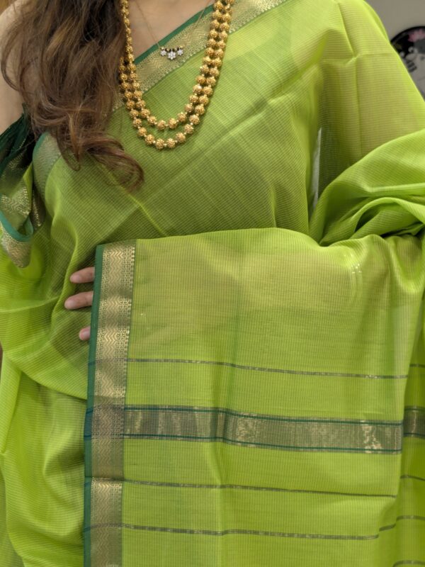 Close-up of parrot green Maheshwari silk-cotton saree with linear design, small zari border
