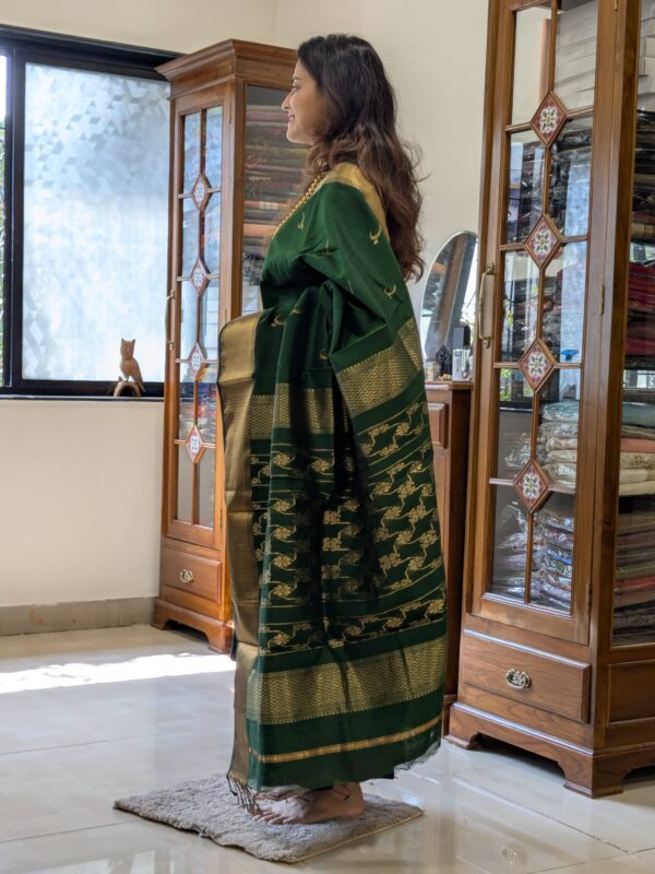 Side view of handloom saree in bottle green showcasing soft drape and rich texture.