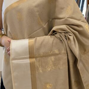 Close-up of beige Maheshwari silk cotton saree with floral motifs, white resham border