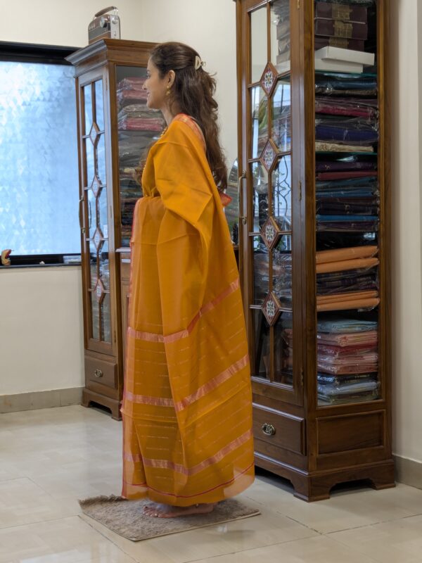 Side view of elegant gold saree showcasing fluid drape, silk-cotton texture, and traditional craftsmanship.