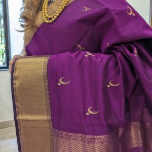 Close-up of magenta Maheshwari saree featuring moon and flower motifs, wide-narrow border