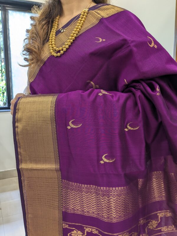 Close-up of magenta Maheshwari saree featuring moon and flower motifs, wide-narrow border