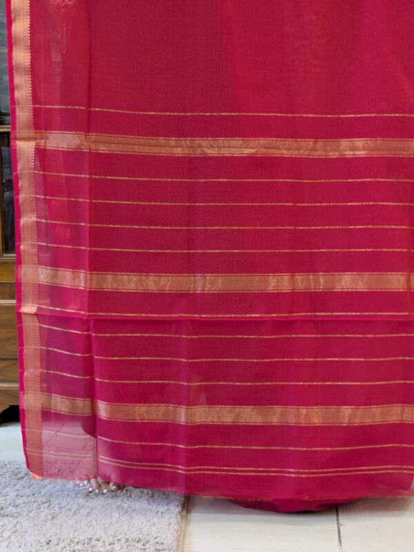 Image of zari-lined pallu featuring shimmering gold lines woven with fine craftsmanship.