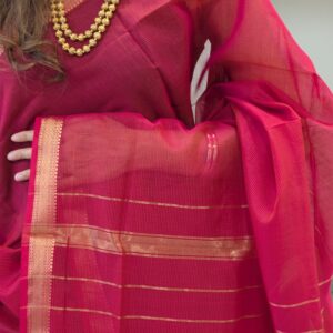 Close-up of rani pink Maheshwari silk-cotton saree with striped pattern, small zari border