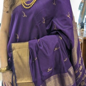 Close-up of purple Maheshwari saree with moon and flower motifs, wide-narrow border