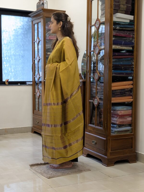 Side view of lightweight sonsali golden saree highlighting fluid drape, silk-cotton texture, and traditional weave.