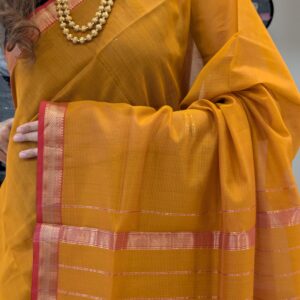 Close-up of rich gold Maheshwari silk-cotton saree with fine lines, small zari border