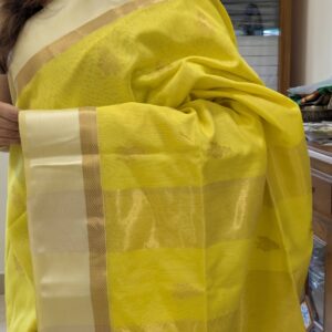 Close-up of fluorescent yellow Maheshwari silk cotton saree with floral motifs, white resham border